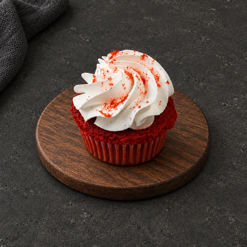 Red Velvet Cupcake with a tall white swirl and red speckles